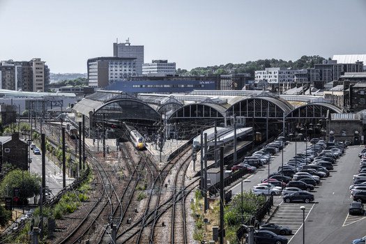 Aerial view of Newcastle Central Station with its arched roof railway tracks trains and an adjacent parking lot in the urban landscape of Newcastle upon Tyne England United Kingdom. Aerial view of Newcastle Central Station with its arched roof railway tracks trains and an adjacent parking lot in the urban landscape of Newcastle upon Tyne England United Kingdom.