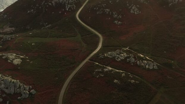Aerial view of a winding road leading to Faro de Punta Nariga Spain.