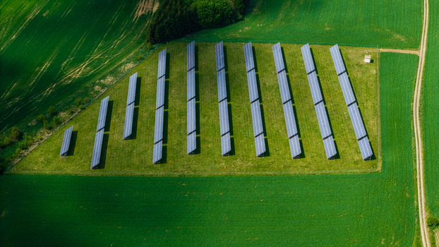 Aerial view of solar panels arranged in rows on a lush green field surrounded by agricultural land in Gruna Pardubicky kraj Czechia. Aerial view of solar panels arranged in rows on a lush green field surrounded by agricultural land in Gruna Pardubicky kraj Czechia.