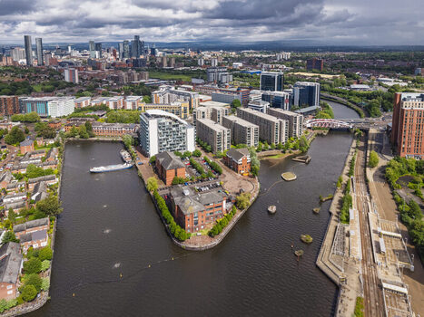 Aerial view of MediaCityUK and modern residential buildings situated along the Manchester Ship Canal with surrounding urban infrastructure and cloudy sky in Salford England United Kingdom. Aerial view of MediaCityUK and modern residential buildings situated along the Manchester Ship Canal with surrounding urban infrastructure and cloudy sky in Salford England United Kingdom.