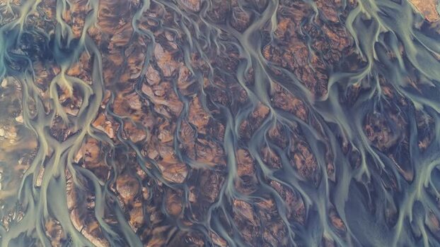 Aerial view of braided glacial river patterns in Iceland.