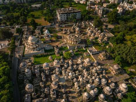 Aerial view of the historic Ahar Cenotaphs featuring numerous stone domes and intricate architecture surrounded by lush greenery in Udaipur Rajasthan India.