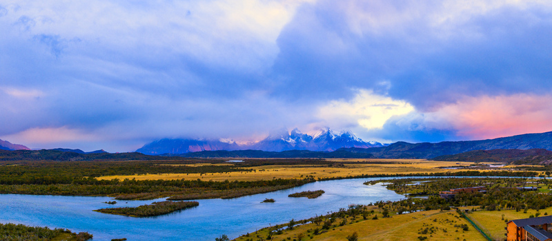Aerial view of Rio Serrano Hotel and Spa by the winding Serrano River with the snow capped peaks of Torres del Paine under a dramatic sunset sky Torres de Paine Magallanes Chile. Aerial view of Rio Serrano Hotel and Spa by the winding Serrano River with the snow capped peaks of Torres del Paine under a dramatic sunset sky Torres de Paine Magallanes Chile.
