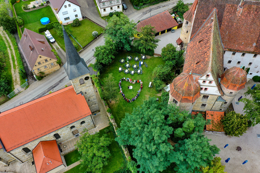 Wiesenthau Germany 09 May 2026 Aerial view of Schloss Wiesenthau and the adjacent church with people standing in a heart shape on the green lawn between historic buildings. Wiesenthau Germany 09 May 2026 Aerial view of Schloss Wiesenthau and the adjacent church with people standing in a heart shape on the green lawn between historic buildings.