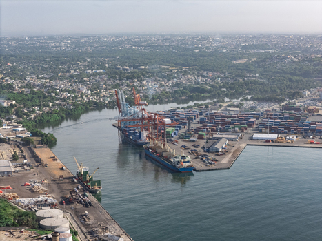 Aerial view of the industrial port of Haina with cargo ships shipping containers and cranes along the coastline in Bajos de Haina San Cristobal Province Dominican Republic.