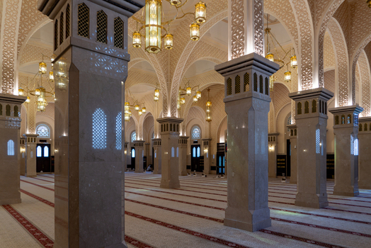 View of the ornate interior of a mosque featuring grand marble pillars intricate arched ceilings and golden chandeliers above patterned prayer carpets Dubai Dubai United Arab Emirates. View of the ornate interior of a mosque featuring grand marble pillars intricate arched ceilings and golden chandeliers above patterned prayer carpets Dubai Dubai United Arab Emirates.