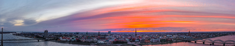 Aerial view of the historic skyline of Riga at sunset with the Daugava River and bridges under a vibrant colorful sky in Riga Latvia. Aerial view of the historic skyline of Riga at sunset with the Daugava River and bridges under a vibrant colorful sky in Riga Latvia.
