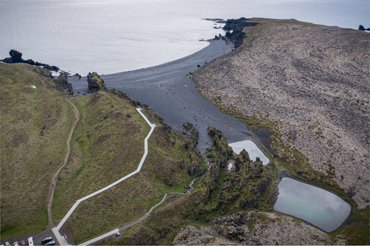 Aerial view of Djupalonssandur beach with its distinctive black volcanic sand rugged cliffs winding walking path and small pools in Iceland. Aerial view of Djupalonssandur beach with its distinctive black volcanic sand rugged cliffs winding walking path and small pools in Iceland.