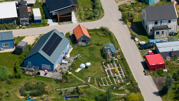 Aerial view of Ecodorp Bolderburen featuring sustainable homes with solar panels lush gardens and a greenhouse in a quiet residential neighborhood in Almere Flevoland Netherlands. Aerial view of Ecodorp Bolderburen featuring sustainable homes with solar panels lush gardens and a greenhouse in a quiet residential neighborhood in Almere Flevoland Netherlands.