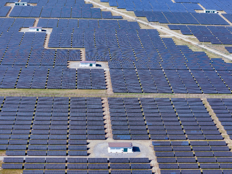 Aerial view of a vast solar farm with rows of photovoltaic panels and small service buildings under bright sunlight in Torrazza Piemonte Piemonte Italy. Aerial view of a vast solar farm with rows of photovoltaic panels and small service buildings under bright sunlight in Torrazza Piemonte Piemonte Italy.