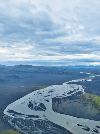 Aerial view of the braided glacial river system of Skyggnisvatn flowing through the dark volcanic landscape and mossy plains near Hella Rangarthing ytra Iceland. Aerial view of the braided glacial river system of Skyggnisvatn flowing through the dark volcanic landscape and mossy plains near Hella Rangarthing ytra Iceland.