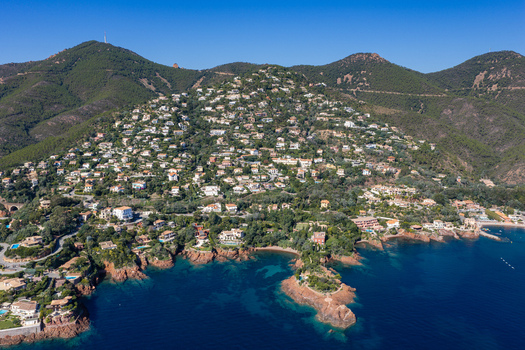 Aerial view of Le Trayas featuring hillside villas nestled among lush greenery overlooking the turquoise Mediterranean Sea in Saint Raphael Provence Alpes Cote d Azur France. Aerial view of Le Trayas featuring hillside villas nestled among lush greenery overlooking the turquoise Mediterranean Sea in Saint Raphael Provence Alpes Cote d Azur France.