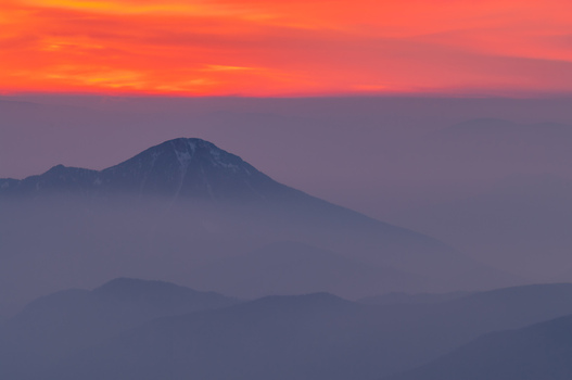 Aerial view of Velky Choc mountain peak rising above a sea of mist during a vibrant sunset with orange and purple hues in Vysny Kubin Zilina Region Slovakia. Aerial view of Velky Choc mountain peak rising above a sea of mist during a vibrant sunset with orange and purple hues in Vysny Kubin Zilina Region Slovakia.