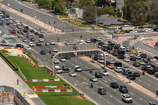 Aerial view of a busy multi lane road intersection with heavy traffic vehicles and green landscaping under bright daylight Dubai Dubai United Arab Emirates. Aerial view of a busy multi lane road intersection with heavy traffic vehicles and green landscaping under bright daylight Dubai Dubai United Arab Emirates.