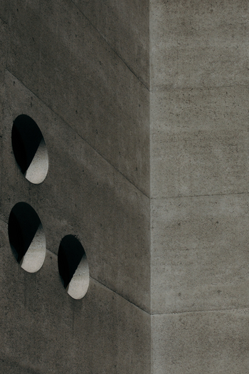 View of stark concrete walls punctuated by circular openings create a modern minimalist aesthetic emphasizing texture and shadow Zurich Switzerland. View of stark concrete walls punctuated by circular openings create a modern minimalist aesthetic emphasizing texture and shadow Zurich Switzerland.