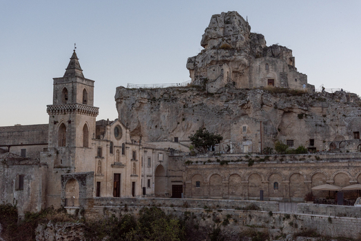 Aerial view of the historic Sassi di Matera with the Chiesa di San Pietro Caveoso and ancient stone dwellings carved into the rocky cliffside in Matera Basilicata Italy.