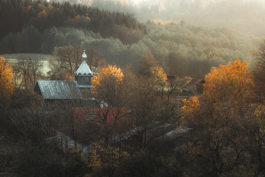 View of the historic wooden Molenna church surrounded by colorful autumn trees and a misty forest at sunrise Wodzilki Podlaskie Voivodeship Poland. View of the historic wooden Molenna church surrounded by colorful autumn trees and a misty forest at sunrise Wodzilki Podlaskie Voivodeship Poland.
