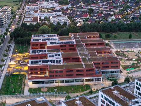 Berlin Germany 07 September 2026 Aerial view of the New School Campus in Adlershof Eisenhutweg with modern red brick buildings green roofs solar panels and landscaped grounds.