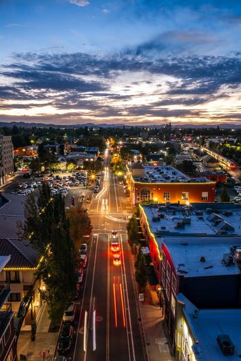 Aerial view of a city street at twilight featuring vibrant car light trails illuminated buildings and street lights in Eugene Oregon United States. Aerial view of a city street at twilight featuring vibrant car light trails illuminated buildings and street lights in Eugene Oregon United States.