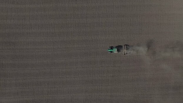 Aerial view of a tractor plowing a field in Portugal. Aerial view of a tractor plowing a field in Portugal.