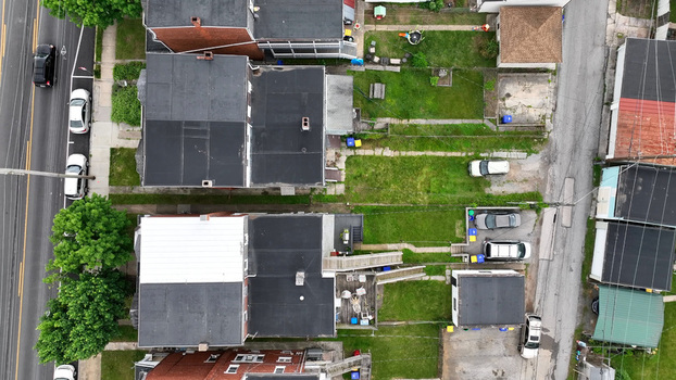 Aerial view of residential houses with flat roofs green backyards and parked cars in a suburban neighborhood in North York Pennsylvania United States.