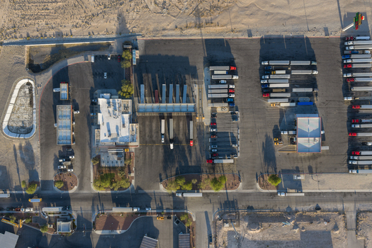Aerial view of a large truck stop with semi trucks parked in rows and long shadows cast across the asphalt in Enterprise Nevada United States. Aerial view of a large truck stop with semi trucks parked in rows and long shadows cast across the asphalt in Enterprise Nevada United States.