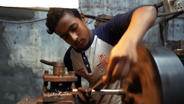 View of a young worker operating a lathe machine Bangladesh.