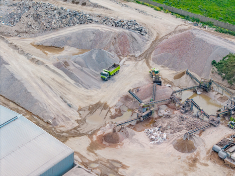 Aerial view of the Philippi quarry featuring a dump truck industrial conveyor belts and large piles of gravel in an industrial site in Cape Town Western Cape South Africa.