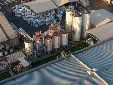 Kilsyth VIC Australia 22 September 2026 Aerial view of industrial factories featuring large metal storage tanks corrugated metal roofing and rows of stacked plastic containers. Kilsyth VIC Australia 22 September 2026 Aerial view of industrial factories featuring large metal storage tanks corrugated metal roofing and rows of stacked plastic containers.