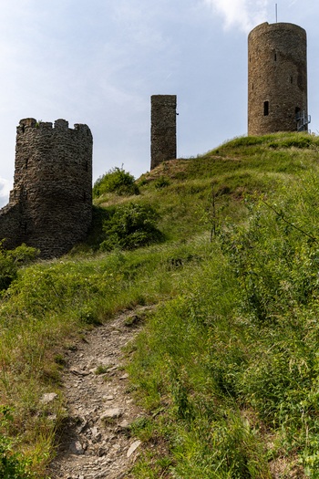 View of Monreal Castle ruins with ancient stone towers on a grassy hill under a bright sky Monreal Rheinland Pfalz Germany. View of Monreal Castle ruins with ancient stone towers on a grassy hill under a bright sky Monreal Rheinland Pfalz Germany.
