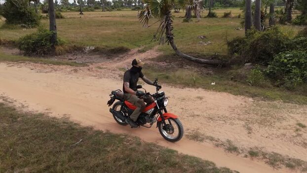 Aerial view of a person riding a red motorcycle in Cambodia. Aerial view of a person riding a red motorcycle in Cambodia.