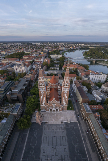 Aerial view of Szeged Cathedral with its distinctive twin towers and red roof overlooking the historic square and the Tisza River in Szeged Hungary. Aerial view of Szeged Cathedral with its distinctive twin towers and red roof overlooking the historic square and the Tisza River in Szeged Hungary.