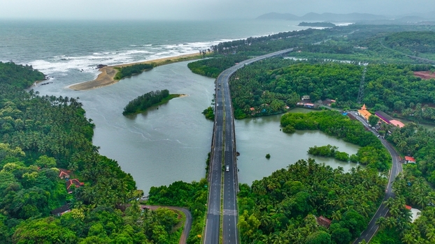 Aerial view of the bridge crossing the river near the coastline of Galgibaga Beach surrounded by lush tropical greenery in Canacona Goa India.