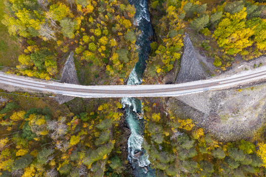 Aerial view of the Kylling Bridge crossing the Rauma River surrounded by vibrant autumn foliage in the forest in Verma More og Romsdal Norway. Aerial view of the Kylling Bridge crossing the Rauma River surrounded by vibrant autumn foliage in the forest in Verma More og Romsdal Norway.