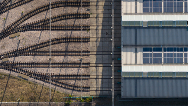 Aerial view of the Rhein Neckar Verkehr GmbH depot with tram tracks concrete platforms and industrial building roof with solar panels in Ludwigshafen am Rhein Rheinland Pfalz Germany. Aerial view of the Rhein Neckar Verkehr GmbH depot with tram tracks concrete platforms and industrial building roof with solar panels in Ludwigshafen am Rhein Rheinland Pfalz Germany.