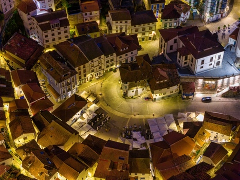 Aerial view of the illuminated Plaza de la Marina at night with traditional colorful houses and outdoor cafe umbrellas in Cudillero Asturias Spain. Aerial view of the illuminated Plaza de la Marina at night with traditional colorful houses and outdoor cafe umbrellas in Cudillero Asturias Spain.