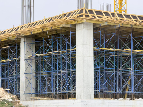 View of concrete pillars and blue scaffolding at a building construction site with wooden formwork Beylikduzu Istanbul Turkey. View of concrete pillars and blue scaffolding at a building construction site with wooden formwork Beylikduzu Istanbul Turkey.