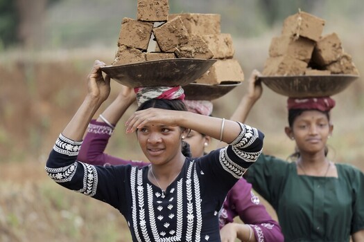 Odisha India 26 March 2026 View of women carrying stacks of earthen bricks on their heads their colorful clothes contrasting with the golden field. Odisha India 26 March 2026 View of women carrying stacks of earthen bricks on their heads their colorful clothes contrasting with the golden field.