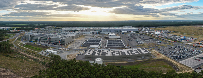 Aerial view of the Tesla Gigafactory Berlin Brandenburg featuring the manufacturing facility solar panels parking lots and forest in Grunheide Mark Brandenburg Germany. Aerial view of the Tesla Gigafactory Berlin Brandenburg featuring the manufacturing facility solar panels parking lots and forest in Grunheide Mark Brandenburg Germany.
