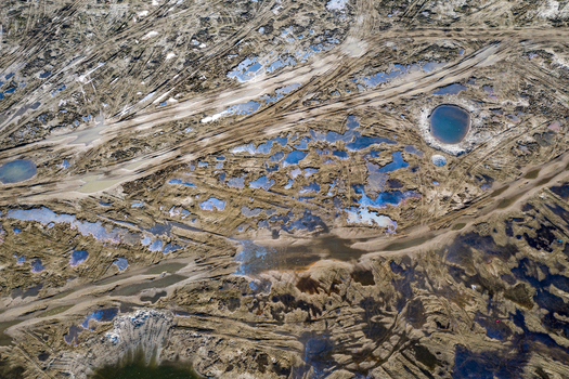 Aerial view of a muddy landscape marked by extensive tire tracks and numerous water filled depressions in Panchagarh Rangpur Division Bangladesh. Aerial view of a muddy landscape marked by extensive tire tracks and numerous water filled depressions in Panchagarh Rangpur Division Bangladesh.