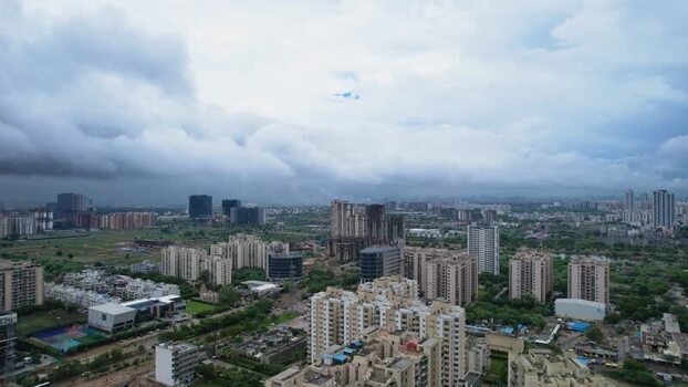 Aerial view of Gurugram cityscape under monsoon clouds India.
