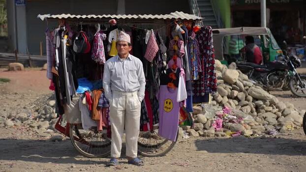 View of a street vendor standing by his mobile clothing stall Nepal. View of a street vendor standing by his mobile clothing stall Nepal.