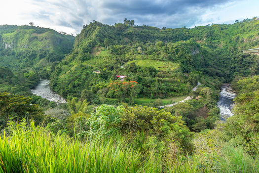View of Estrecho del Rio Magdalena with lush green hills a winding road and the Magdalena River flowing through the landscape in San Agustin Huila Colombia.