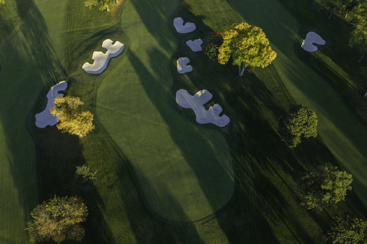 Aerial view of a golf course in autumn with sand bunkers green fairways and trees with yellow foliage in Glenview Illinois United States. Aerial view of a golf course in autumn with sand bunkers green fairways and trees with yellow foliage in Glenview Illinois United States.
