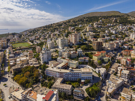 Aerial view of the coastal city of Saranda with its hillside residential buildings Mediterranean architecture and scenic views of the Ionian Sea in Saranda Vlore County Albania. Aerial view of the coastal city of Saranda with its hillside residential buildings Mediterranean architecture and scenic views of the Ionian Sea in Saranda Vlore County Albania.