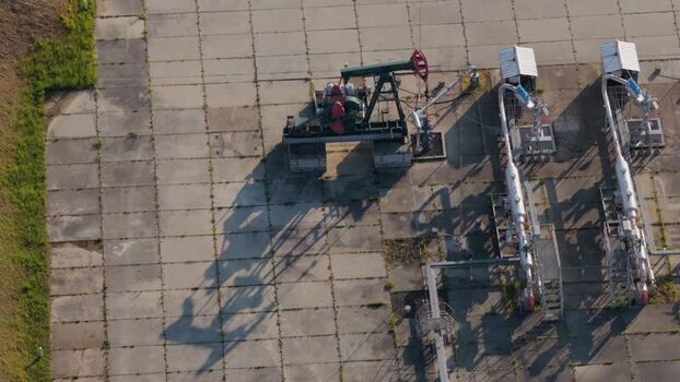 Aerial view of an oil pump jack and industrial pipes Czechia. Aerial view of an oil pump jack and industrial pipes Czechia.
