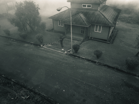 Aerial view of a building shrouded in mist the street reflecting soft light creating an ethereal scene Obudu Cross River Nigeria.