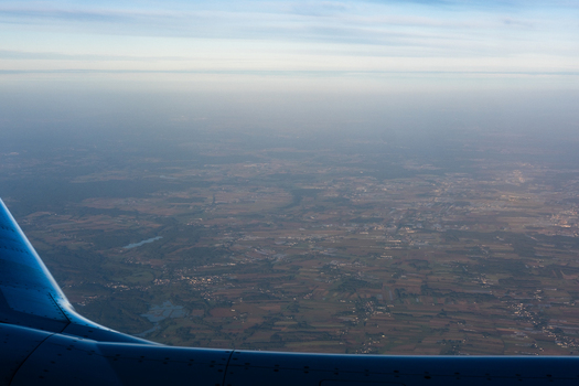 Aerial view of the earth covered with fields and houses as seen from an airplane window Warsaw Masovian Voivodeship Poland. Aerial view of the earth covered with fields and houses as seen from an airplane window Warsaw Masovian Voivodeship Poland.