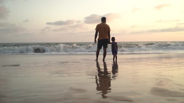 View of a man and child at sunset on a beach Sri Lanka. View of a man and child at sunset on a beach Sri Lanka.