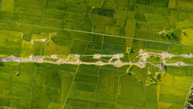 Aerial view of the vibrant green rice paddies and irrigation channels surrounding Lak Lake in Lien Son Lak Dak Lak Vietnam. Aerial view of the vibrant green rice paddies and irrigation channels surrounding Lak Lake in Lien Son Lak Dak Lak Vietnam.